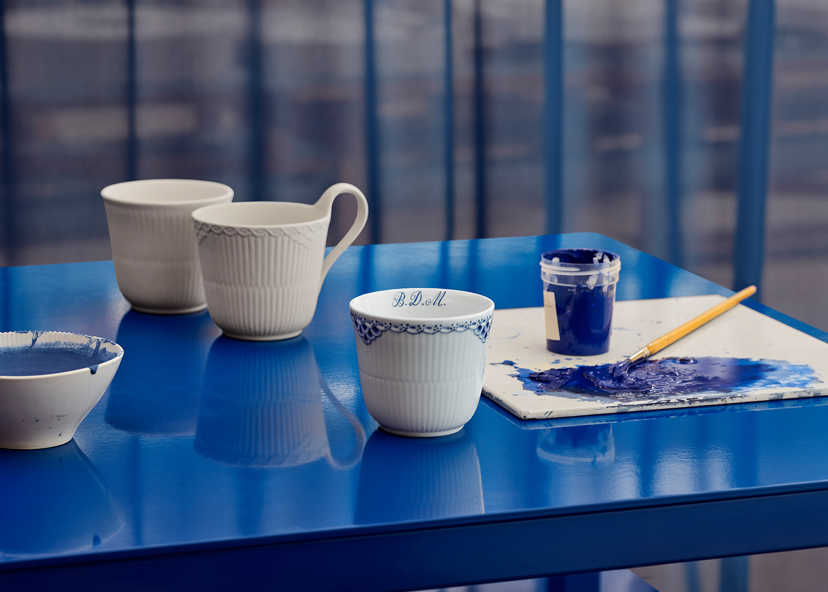 Royal Copenhagen Cups and Mugs standing on a blue desk - ready to be painted with a name
